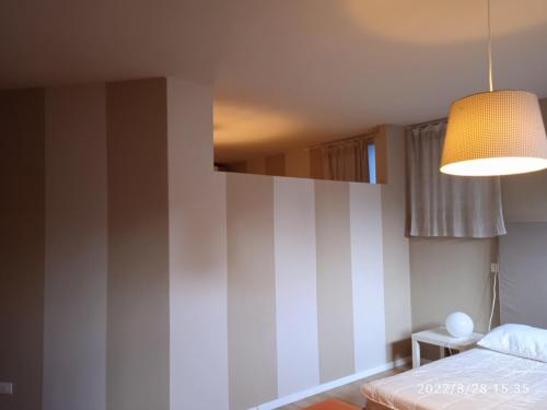 a bedroom with a bed and a light fixture at Appartamento seminterrato Villa Sveva Franciacorta in Ome