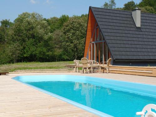 a swimming pool with chairs and a house at Dosbajka in Małastów