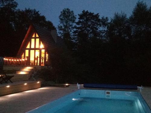 a swimming pool in front of a house at night at Dosbajka in Małastów