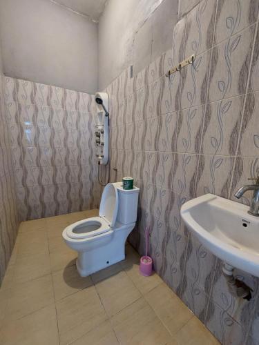 a bathroom with a toilet and a sink at Karibu House in Paje