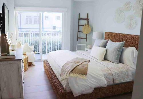 1 dormitorio con 1 cama grande y balcón en Your Happy Place ON THE BEACH!, en Key Colony Beach