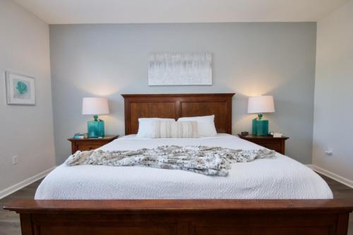 a bedroom with a bed with white sheets and two lamps at Vista Cay Luxury Retreat condo in Orlando