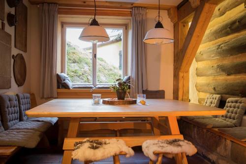 ein Esszimmer mit einem Holztisch und einem Fenster in der Unterkunft Kulturdenkmal Umgebinde1657 in Bad Schandau