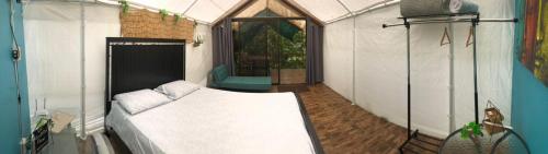 1 dormitorio con 1 cama blanca en una habitación en Garza del Sol Glamping Río Celeste Bromelia, en San Rafael