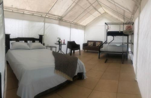 San Rafael的住宿－Glamping Rio Celeste Heliconia，一间卧室配有一张床铺,帐篷内提供一把椅子