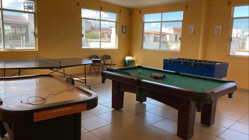 2 tafeltennistafels in een kamer met ramen bij Hotel El Mirador in Tequisquiapan