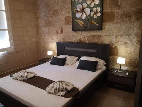 a bedroom with a bed with two pillows on it at Two gate town house in Senglea