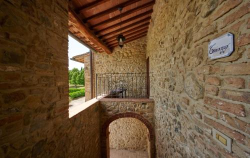 a stone building with a balcony on the side of it at Agriturismo La Peschiera in Casole dʼElsa