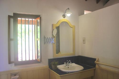a bathroom with a sink and a mirror and a window at Sagala Boutique Hotel in Bandarawela