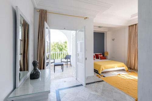 1 dormitorio con 1 cama y 1 habitación con ventana en villa Pergola en Hammamet