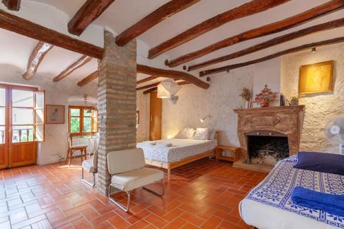 1 dormitorio con 1 cama y chimenea en Cal Joanet, acollidora caseta a Gratallops, en Gratallops