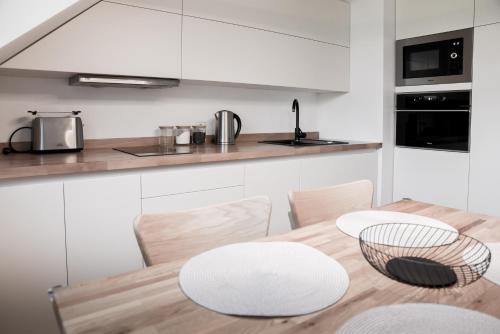 cocina y comedor con mesa de madera y sillas en Apartmán na Pasekách en Bystrzyca