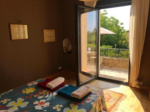 una camera da letto con un letto e una porta scorrevole in vetro di Maison au calme au coeur de village a Saint-Georges-dʼOrques