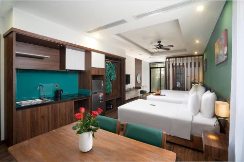 a bedroom with a bed and a table and a kitchen at Chi House Danang Hotel and Apartment in Da Nang