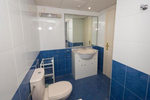 baño azul y blanco con aseo y lavamanos en Appartement équipé CALPE Espagne, 4 couchages, terrasse, piscines, climatisation, garage et WIFI gratuits, en Calpe