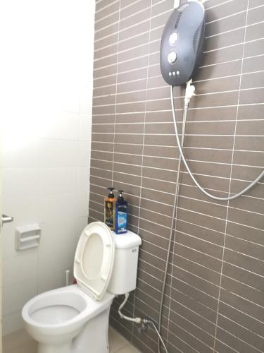 a bathroom with a toilet with a blow dryer on the wall at Palazio AegeanSea Homestay By Easyhomestay in Johor Bahru