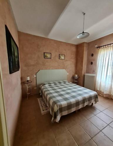 PortacomaroにあるA casa di Biancaのベッドルーム1室(チェック入りの毛布付きのベッド1台付)