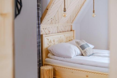 Bett mit weißer Bettwäsche und Kissen in einem Zimmer in der Unterkunft Olczańska Kotlina Apart&Room in Zakopane