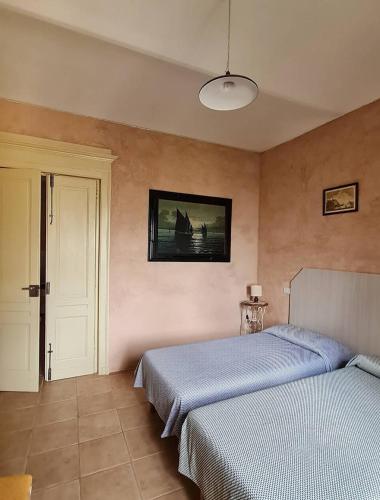 a bedroom with two beds and a painting on the wall at A casa di Bianca in Portacomaro