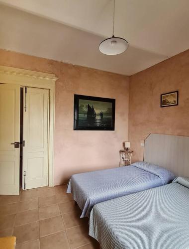 PortacomaroにあるA casa di Biancaのベッドルーム1室(ベッド2台付)が備わります。壁には絵画が飾られています。