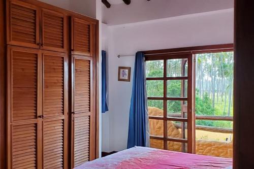 sypialnia z łóżkiem i dużym oknem w obiekcie Villa Vacacionales Los Cayos Con Playa Privada w mieście Boca de Aroa