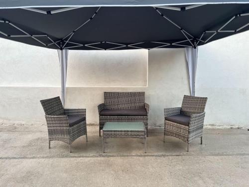 un groupe de chaises et une table sous un parapluie dans l'établissement Maison avec Jacuzzi Marseille, à Marseille