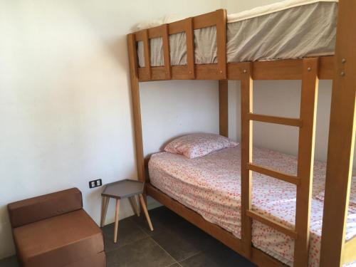 a bedroom with two bunk beds and a chair at Los Libertadores Paracas Beach House in Paracas