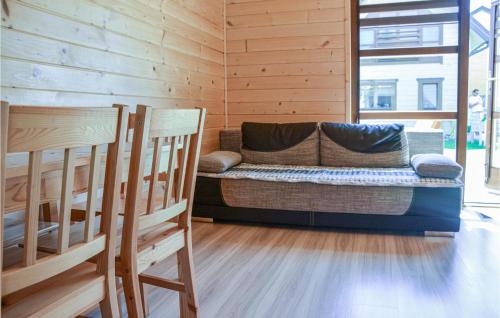 una sala de estar con sofá en una cabaña de madera en Cozy Home In Grzybowo With Kitchen, en Grzybowo