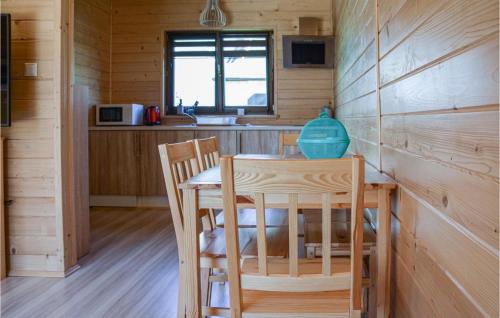 una cocina con mesa y sillas en una cabaña en Cozy Home In Grzybowo With Kitchen, en Grzybowo