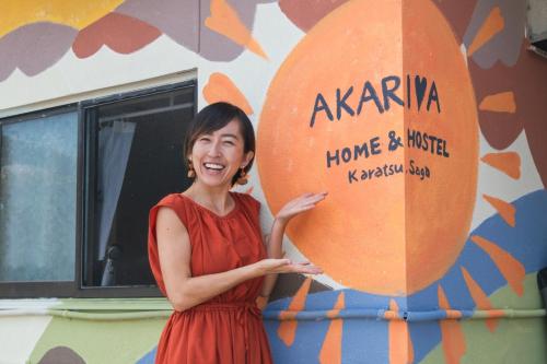 a woman in a red dress holding a large orange balloon at AKARIYA Home&Hostel in Karatsu