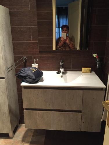a woman taking a picture of a bathroom sink at Costa Antigua II in Costa de Antigua