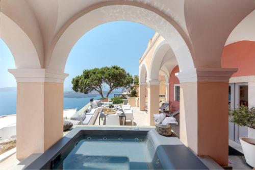 an outdoor swimming pool in a building with an archway at Coat of Arms Mansion in Fira