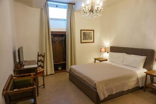 Schlafzimmer mit einem Bett, einem Fenster und einem Kronleuchter in der Unterkunft DreaMilan B&B in Mailand