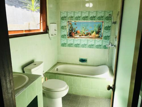 La salle de bains est pourvue de toilettes, d'une baignoire et d'un lavabo. dans l'établissement Ayu Bisma Homestay, à Ubud
