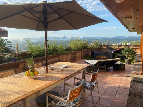 a wooden table with an umbrella on a patio at Ondarreta Beach - Singular y exclusivo in Donostia-San Sebastián
