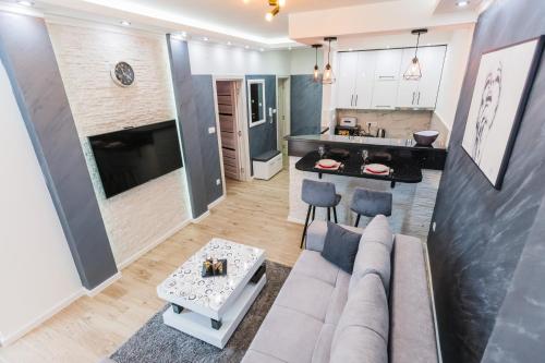uma sala de estar com um sofá e uma cozinha em JACUZZI LUX SANJA em Subotica