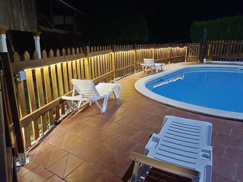 a patio with chairs and a swimming pool at night at 4 bedrooms villa with private pool enclosed garden and wifi at Empalme de Vilar in Vilar