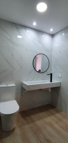 a white bathroom with a mirror and a toilet at Alójate Gandia Ermita in Gandía