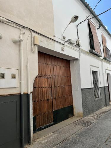 a building with a wooden door on a street at Apartamento en calle Rocio-Triana in Seville
