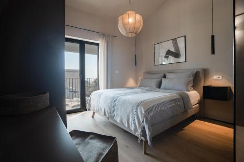 een slaapkamer met een bed en een groot raam bij Villa Bewegte Berge in Kaštelir