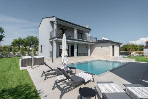 une villa avec une piscine et une maison dans l'établissement Villa Bewegte Berge, à Kaštelir