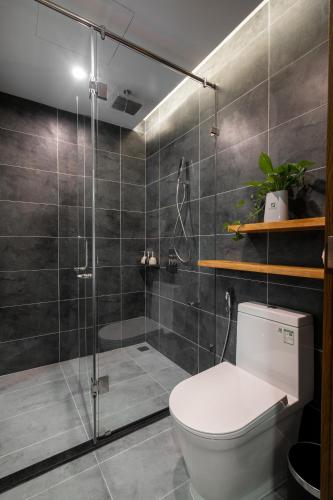 a bathroom with a toilet and a glass shower at Chi House Danang Hotel and Apartment in Da Nang