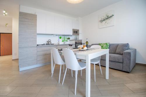 a kitchen and dining room with a white table and chairs at AbruzzodAmare Amazing Apartments with Romantic Sea View in Francavilla al Mare