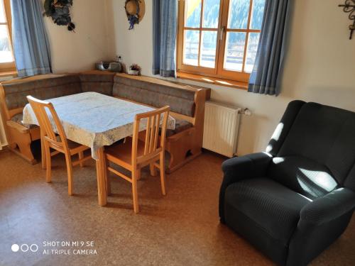 a living room with a table and chairs and a couch at Gästehaus Laßnig in Ebene Reichenau