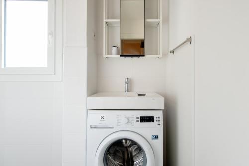 a washer and dryer in a bathroom with a sink at 2 apartments next to a market and Piazza Santa Croce - HomeUnity in Florence