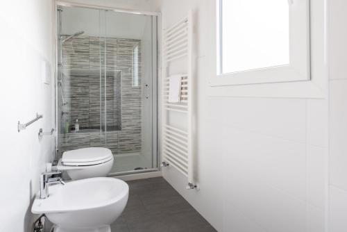 a white bathroom with a toilet and a sink at 2 apartments next to a market and Piazza Santa Croce - HomeUnity in Florence