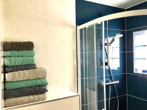 a bathroom with a shower and a stack of towels at Cassis Ma Vie Là in Cassis