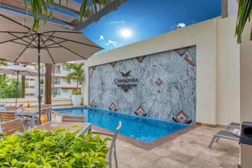 a pool at a hotel with chairs and an umbrella at Casa Nicole Boutique Hotel in Puerto Vallarta