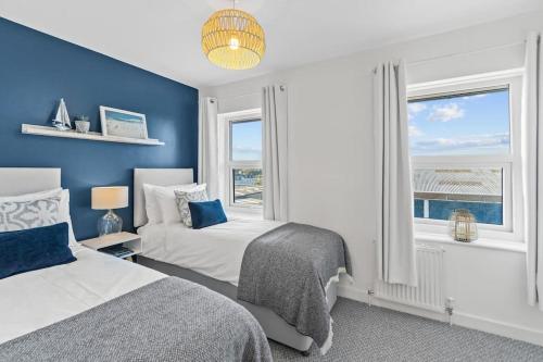sypialnia z 2 łóżkami i niebieską ścianą w obiekcie Charming Sea Haven House, Close to the Marina w mieście Plymouth