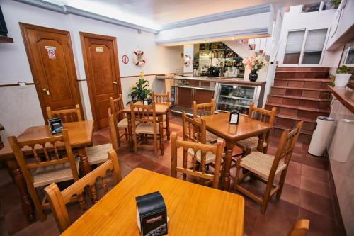 a restaurant with wooden tables and chairs and stairs at Hostal Azul in La Antilla